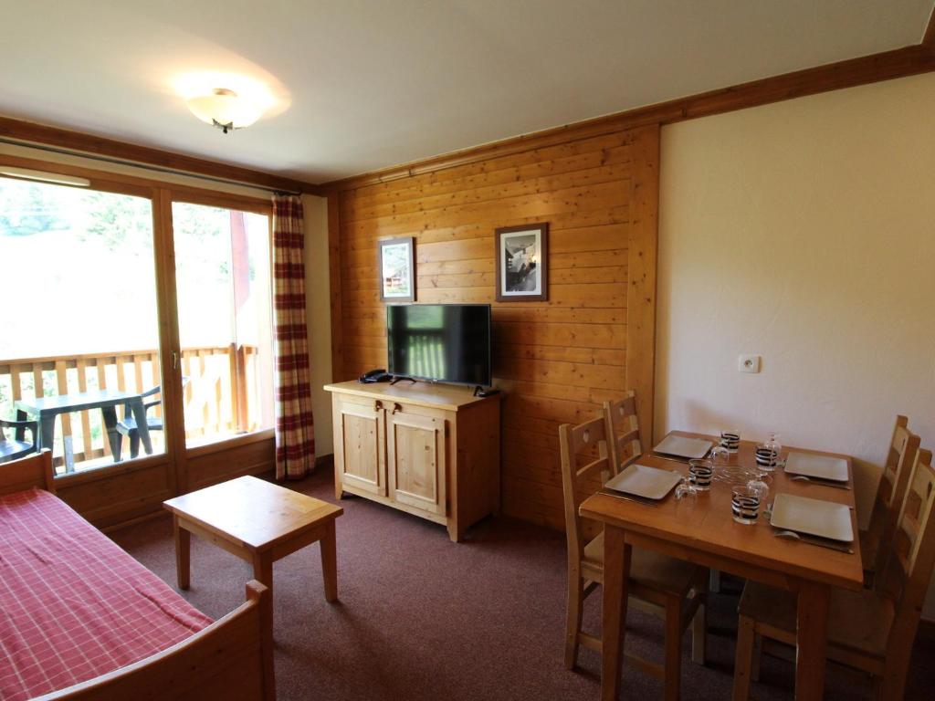 a room with a table and chairs and a kitchen at Appartement 4 pers. pied des pistes avec piscine et parking, Lanslebourg-Val Cenis - FR-1-508-251 in Lanslebourg-Mont-Cenis