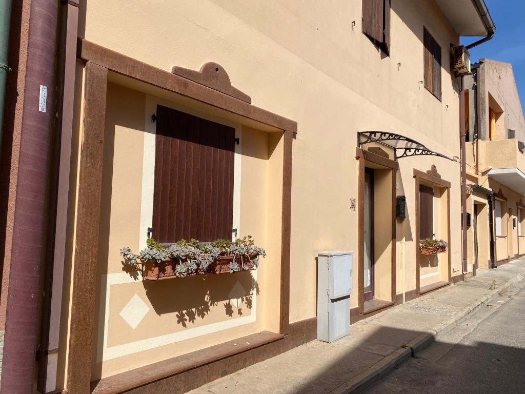 a building with a window with potted plants on it at Concas Apartaments in Portoscuso
