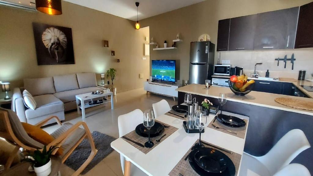 eine Küche und ein Wohnzimmer mit einem Sofa und einem Tisch in der Unterkunft Paramount Gardens Resorts C202 in Larnaka