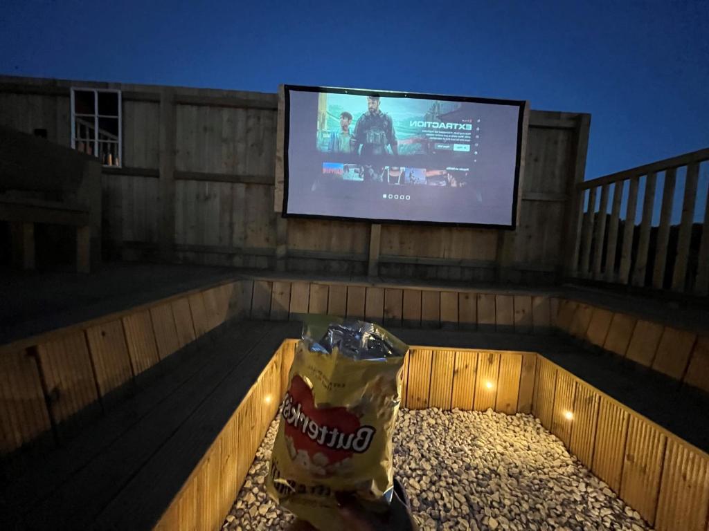 uma televisão numa varanda com um saco de batatas fritas em Robin Hood Safari Tent em Tenby