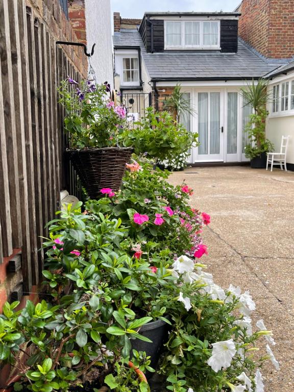 a bunch of flowers in a basket on the side of a house at The old coach house 8 North lane in Kent