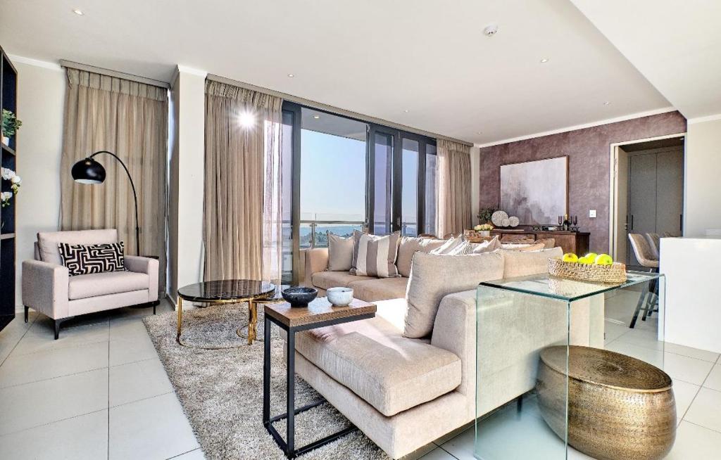 un salon avec un canapé et une table dans l'établissement Modern Luxury furnished apartments in Sandton - Two bed Executive, Two bed Deluxe and Three Bed Executive with Balconies, à Johannesbourg