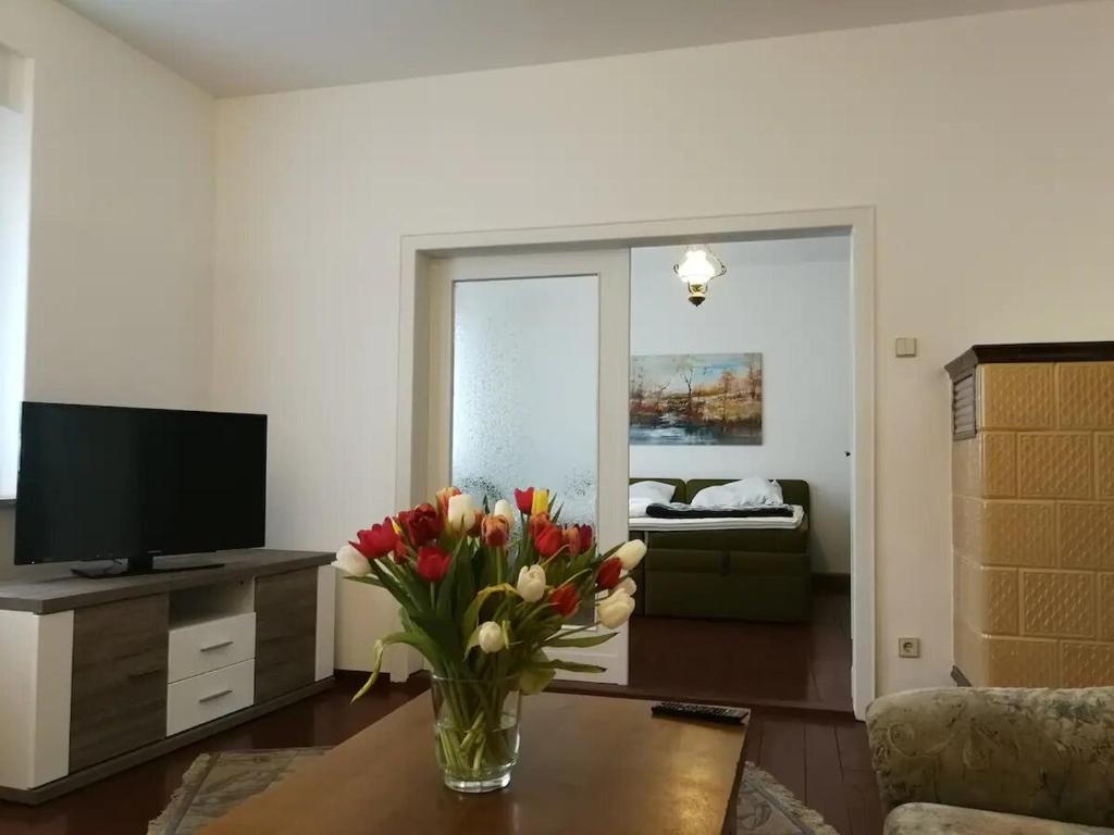 ein Wohnzimmer mit einer Blumenvase auf dem Tisch in der Unterkunft Ferienwohnung in Cottbus-Klein Ströbitz Nähe Badesee in Cottbus
