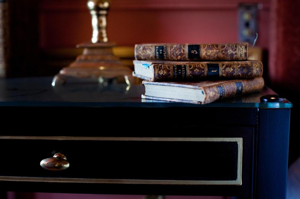 a stack of books sitting on top of a table at Relais & Château Louise de La Vallière in Reugny