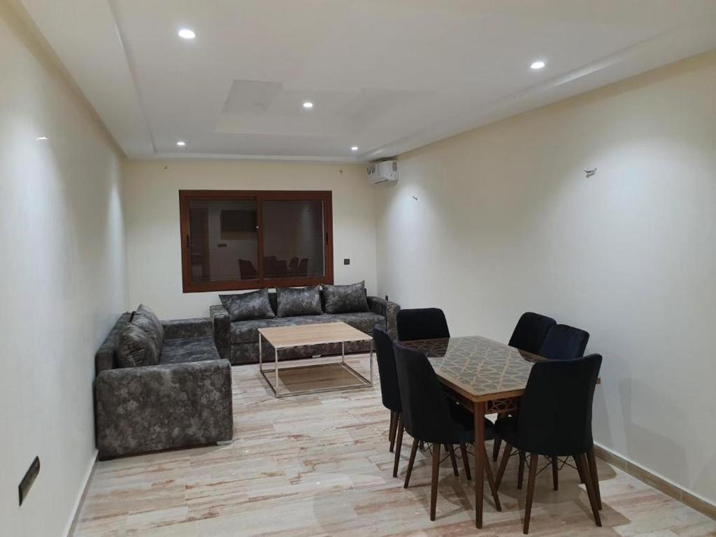 un salon avec un canapé, une table et des chaises dans l'établissement Les Belles Residences E, à Tanger
