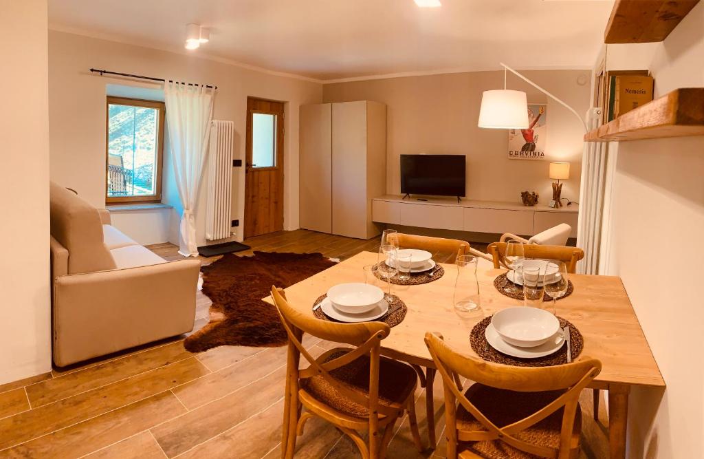 una cucina e un soggiorno con tavolo e sedie di La Tsambra-Le Four des Alpes a Rhemes-Saint-Georges