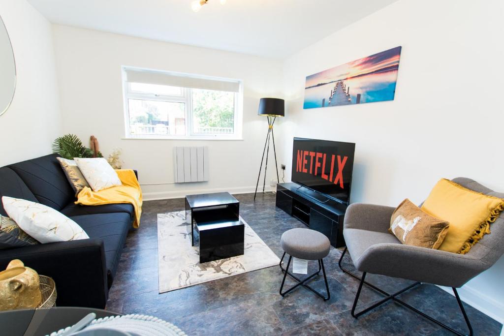 ein Wohnzimmer mit einem Sofa und einem Stuhl in der Unterkunft K Suites - Flat 114 Fulbridge Road in Peterborough