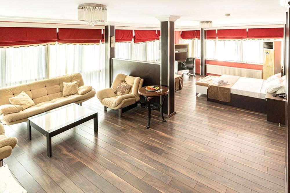 sala de estar con sofá y cama en Pamuk City Hotel, en Gaziantep