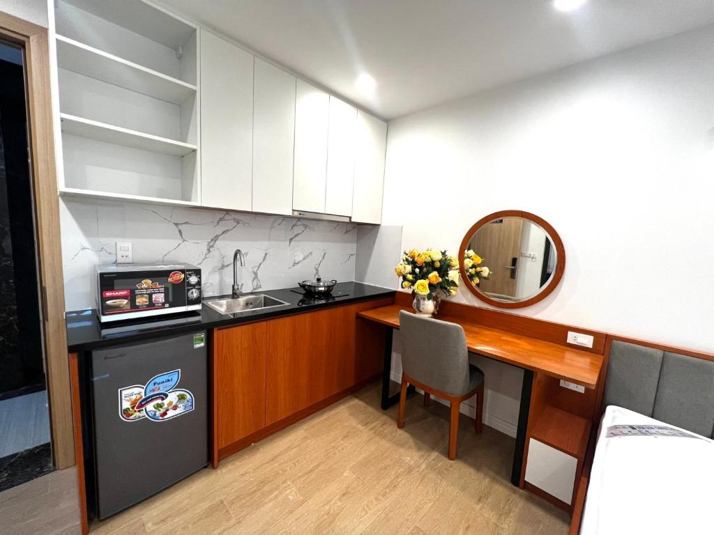 een kleine keuken met een bureau en een wastafel bij Era Cozy Apartment in Hanoi