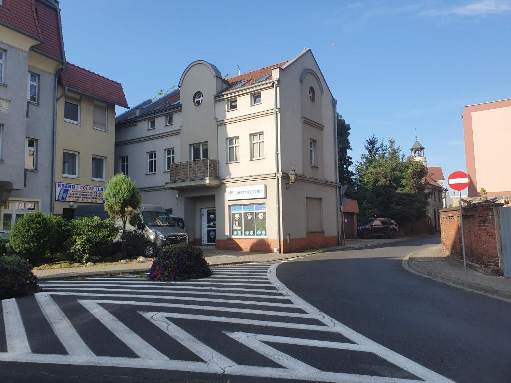 an empty street with a crosswalk in front of a building at Apartamenty Wałowa 11 in Leszno