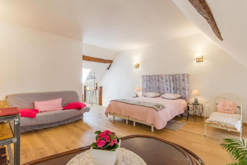 a living room with a bed and a couch at Au coeur du Chat Perché in Arnay-le-Duc