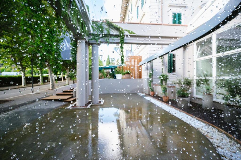 un patio con gotas de lluvia en el suelo de un edificio en Palazzo BelVedere en Montecatini Terme