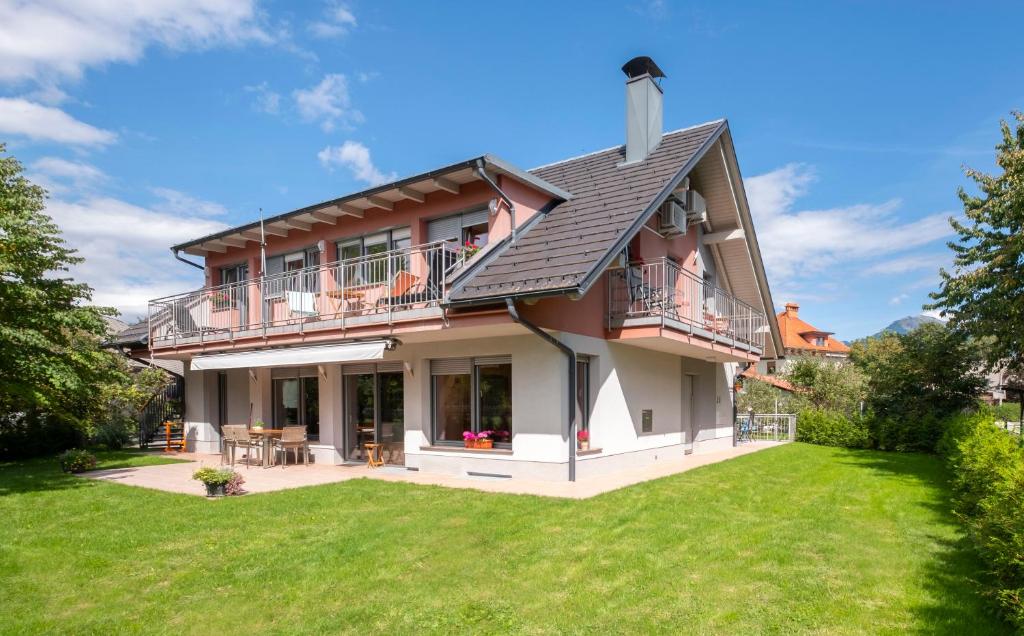 uma casa grande com um relvado em frente em Apartments Apple Garden 4P em Bled