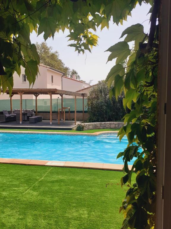 una piscina con prato verde e padiglione di superbe grand studio tout confort avec exterieur a Poussan