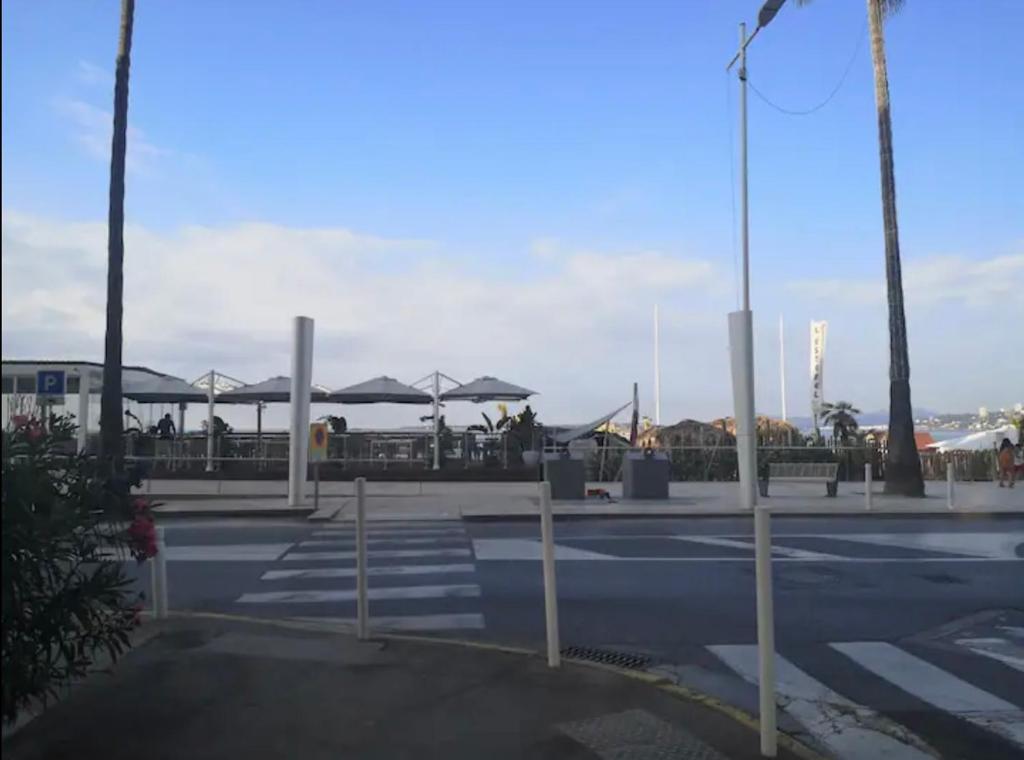 un aparcamiento con mesas y sombrillas en Impeccable 3 pièces avec balcons, la plage à 50m, en Antibes