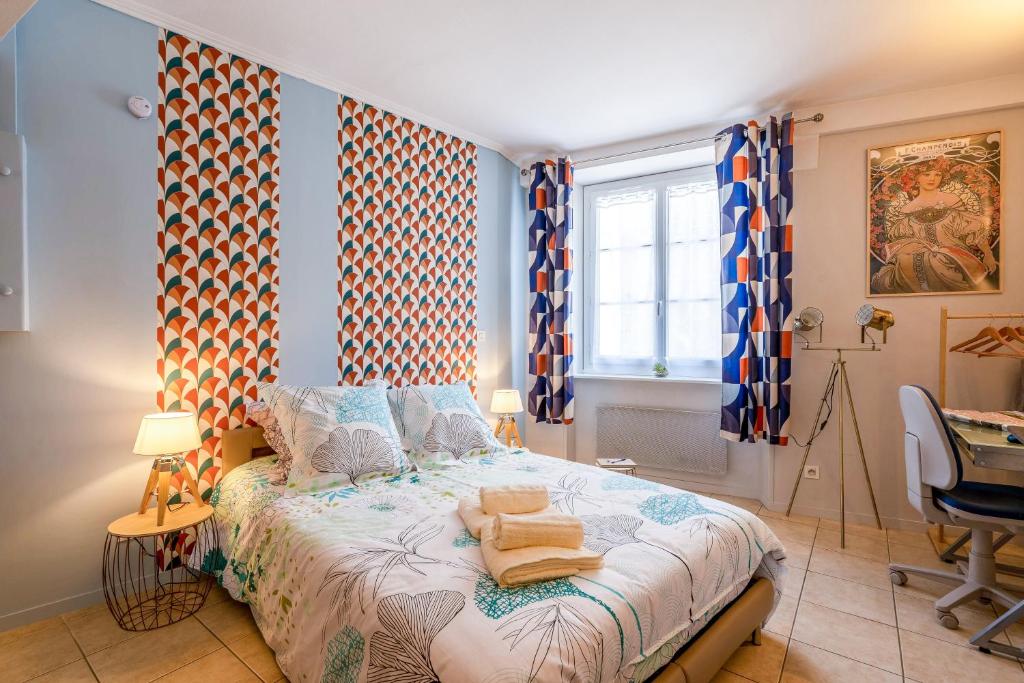 a bedroom with a bed and a desk and windows at SUPERLOGIS - Bel Epoque - STUDIO Classé 3 étoiles - BLOIS-HYPERCENTRE in Blois