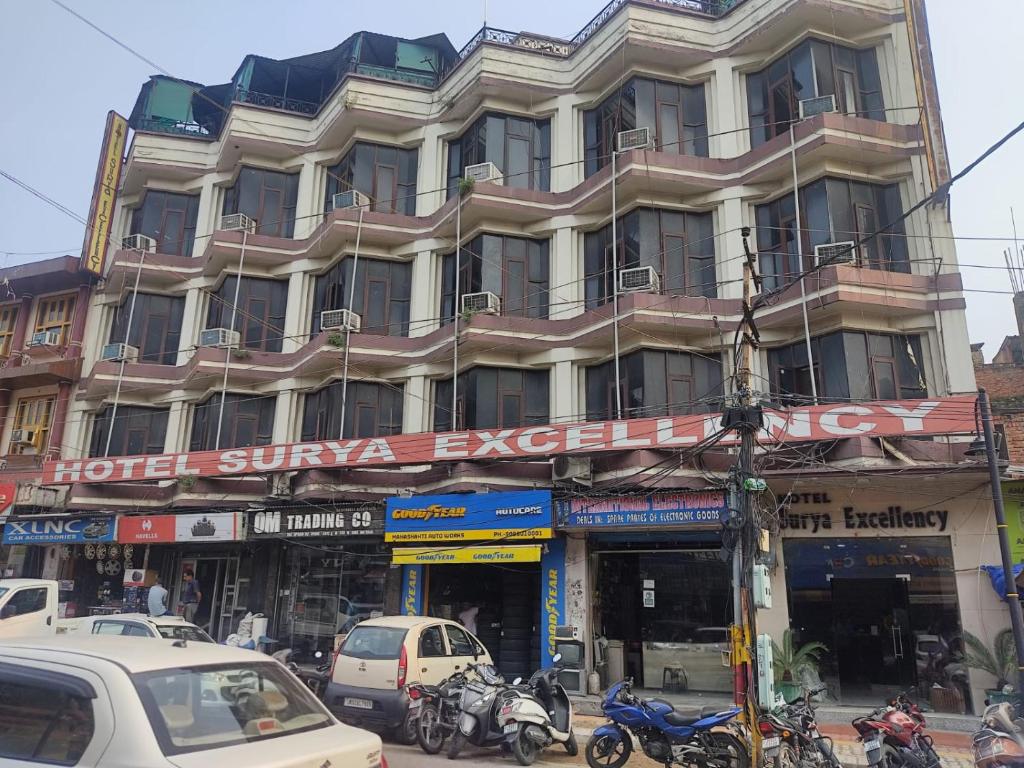 a large building on a street with cars and motorcycles at Hotel Surya Excellency By WB Inn in Jammu