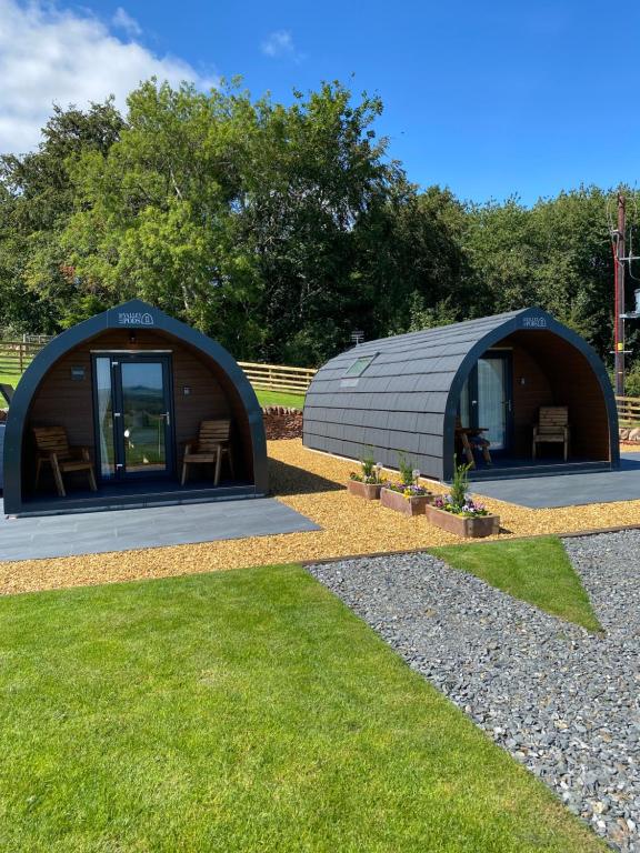 Craigend Farm Holiday Pods - The Woolly Sheep في دومفريس: قبة كبيرة على شكل مبنى مع كراسي في العشب