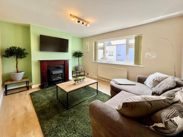 uma sala de estar com um sofá e uma lareira em Knick Knack - 10 Minutes Stroll from Brixham Harbour em Brixham