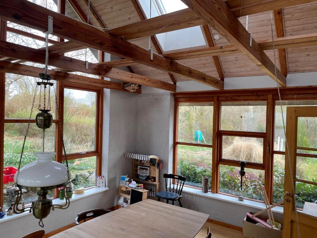 une chambre avec des fenêtres et une table en bois dans une maison dans l'établissement Dejligt hus på landet, à Give
