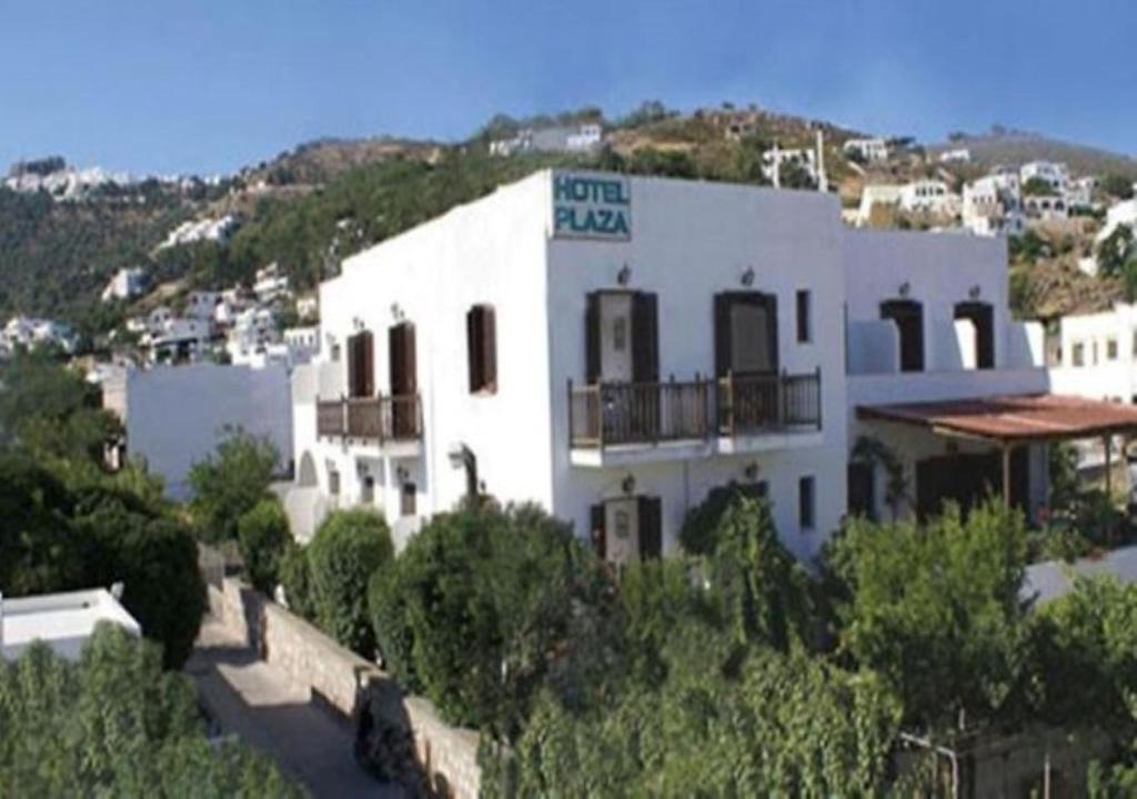 a large white building on top of a hill at Plaza Hotel in Skala