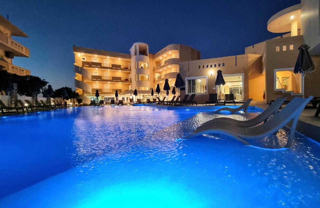 a swimming pool in front of a hotel at night at Sunny Bay Hotel in Kissamos