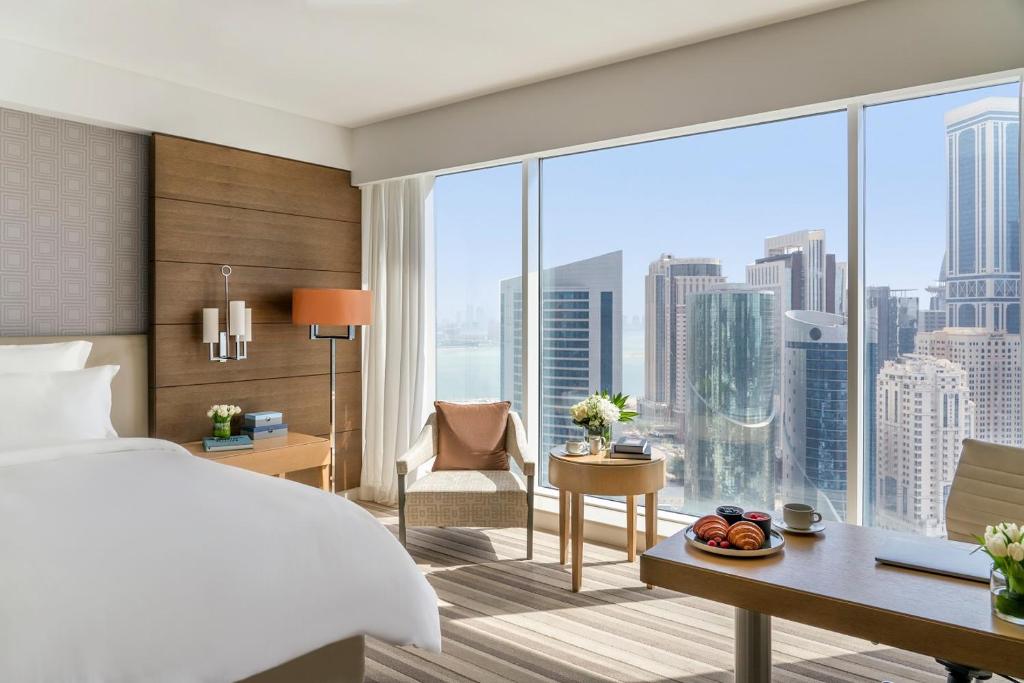 a hotel room with a bed and a large window at Pullman Doha West Bay in Doha
