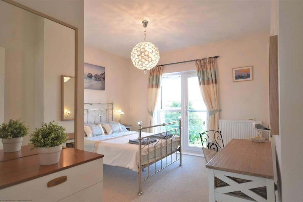 a bedroom with a bed and a large mirror at Pebble House (Goring-by-Sea) in Worthing