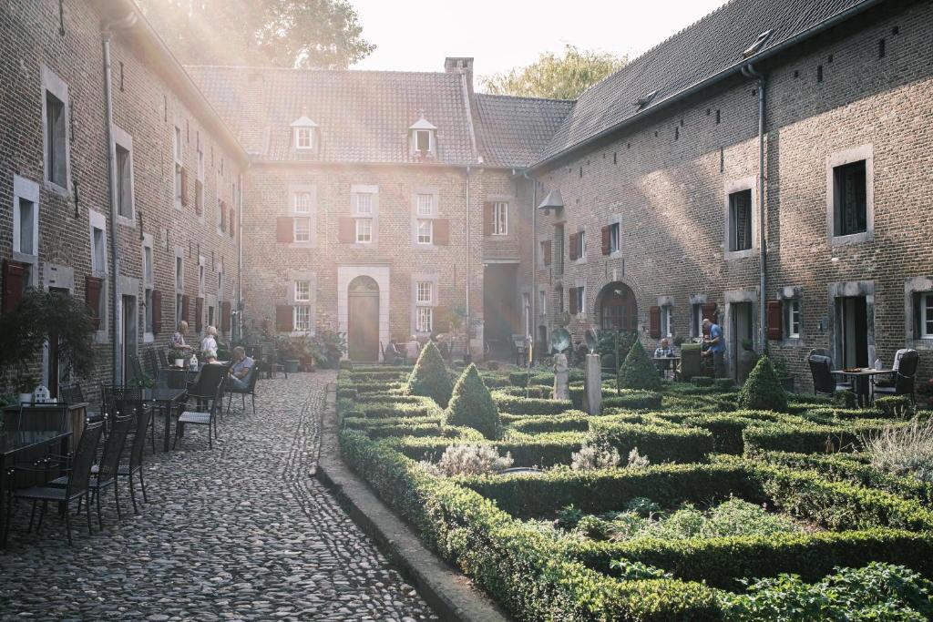 een binnenplaats met een tuin en tafels bij Meschermolen 2 in Eijsden