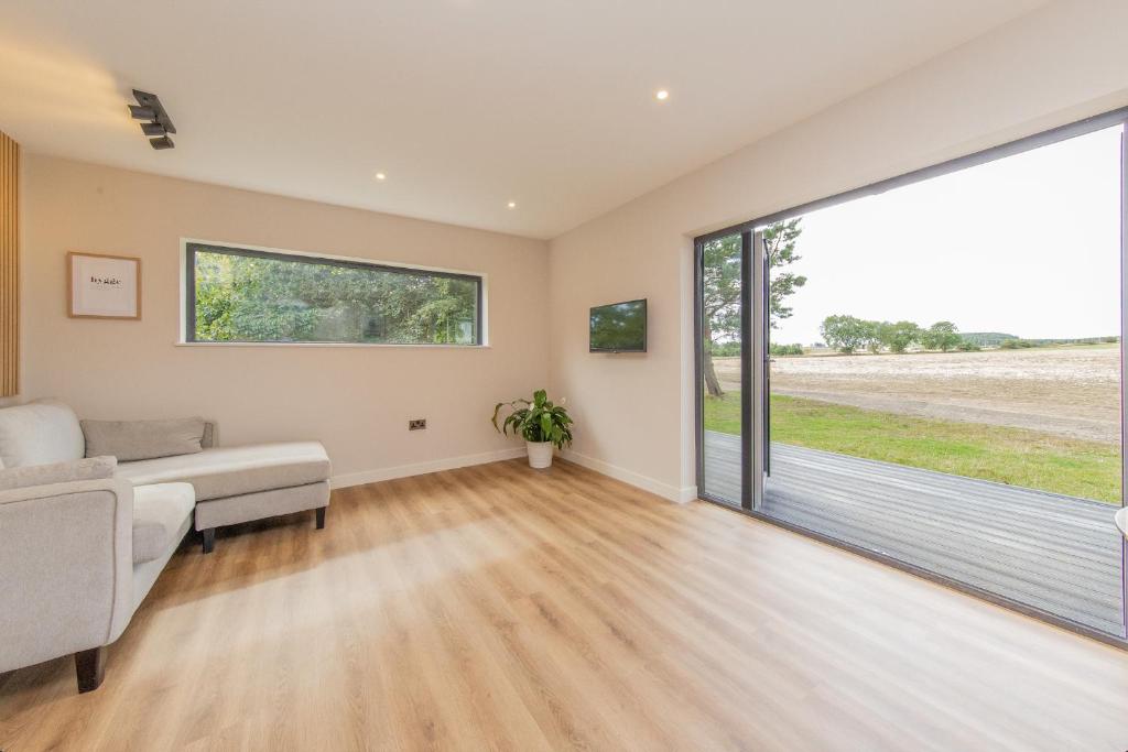 a living room with a couch and a large sliding glass door at Hygge at Vallum in Newcastle upon Tyne