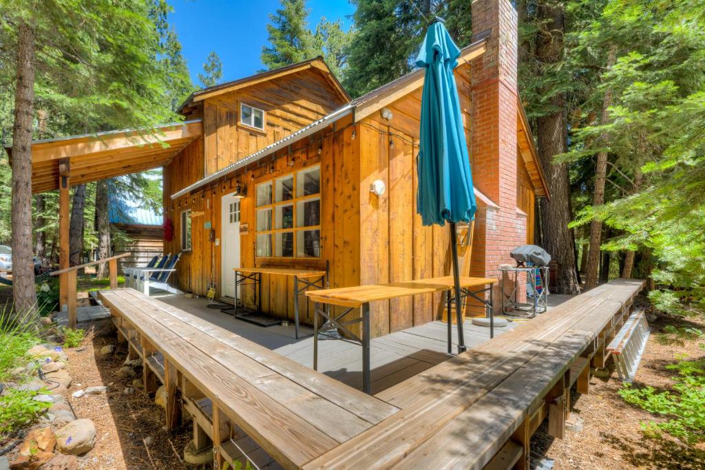 a cabin with a wooden deck with an umbrella at Truly Tahoe in Homewood