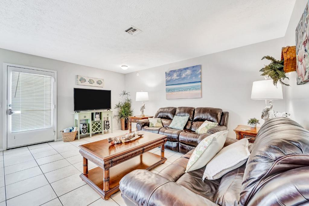 ein Wohnzimmer mit Ledermöbeln und einem Flachbild-TV in der Unterkunft Blissful Beach Retreat B in Englewood