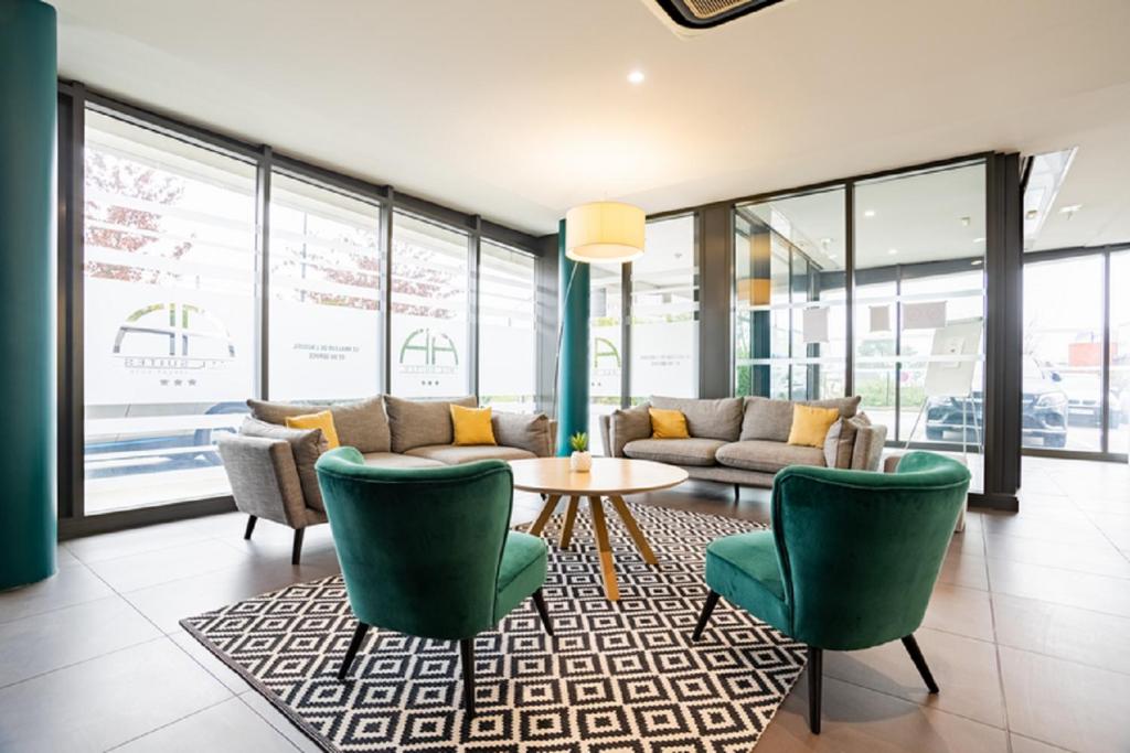 ペサックにあるAll Suites Appart Hôtel Bordeaux Pessacのロビー(ソファ、椅子、テーブル付)