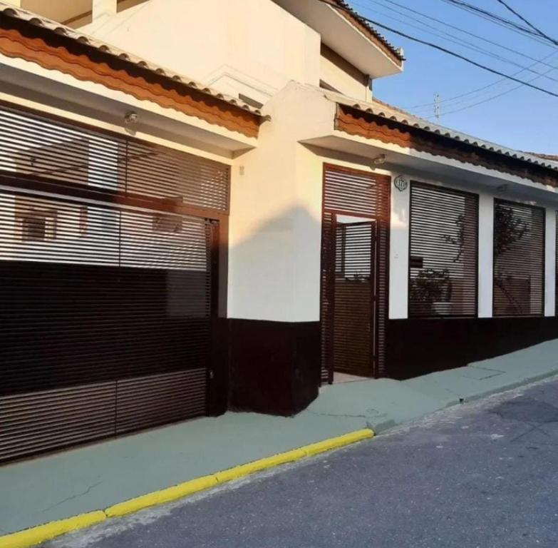 dom z dwoma drzwiami garażowymi i ulicą w obiekcie Pousada Deus é Fiel w mieście Cachoeira Paulista