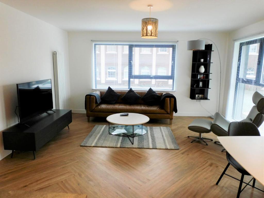 ein Wohnzimmer mit einem Sofa und einem Tisch in der Unterkunft Brand new gorgeous 2 bed Apt in Finnieston in Glasgow