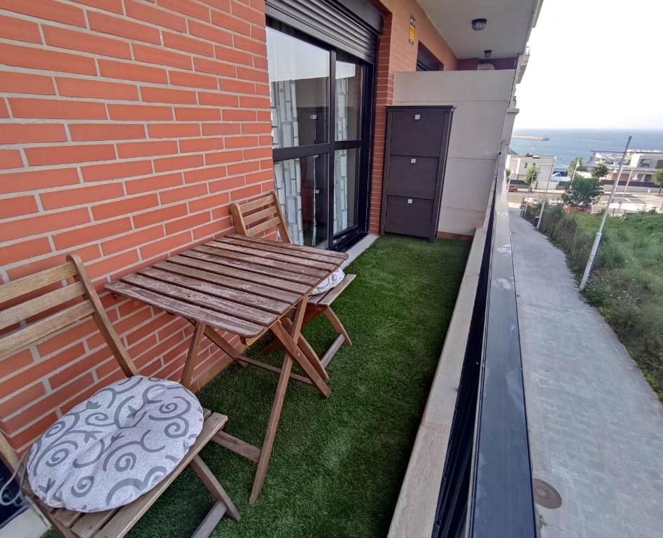 - Balcón con mesa de madera y 2 sillas en Precioso apartamento con terraza, pistas de padel y piscinas, en Castro Urdiales