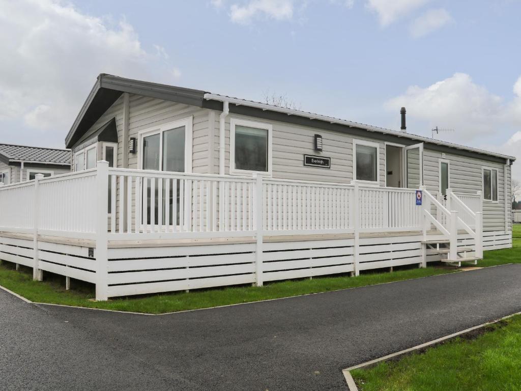 a mobile home with a white fence at Lodge at Chichester Lakeside 2 Bed in Chichester