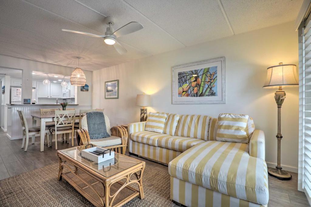a living room with a couch and a table at Colorful Oceanside Condo with Beach Access! in Saint Augustine Beach