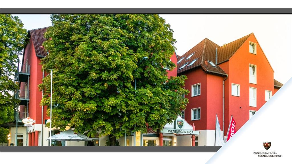 un gran árbol frente a un edificio en Konferenzhotel Ysenburger Hof, en Langenselbold