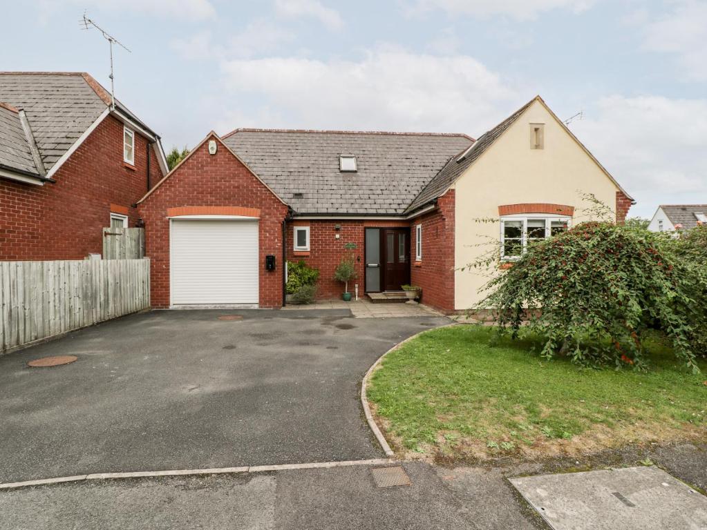 a red brick house with a white garage at Hurst Green in Ewyas Harold