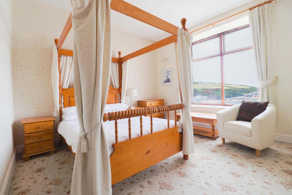 a bedroom with a four poster bed and a window at Falcon's Nest Hotel in Port Erin