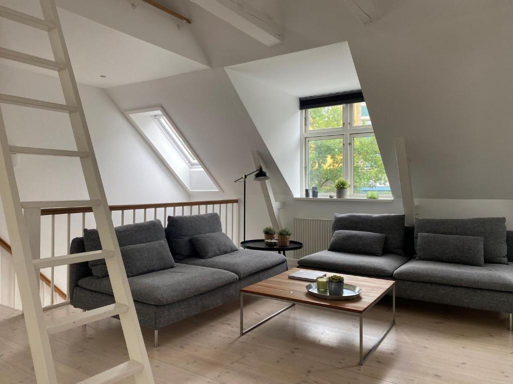 una sala de estar con 2 sofás y una escalera en ApartmentInCopenhagen Apartment 1470 en Copenhague