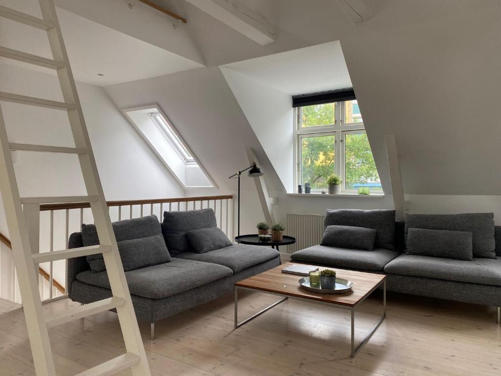 uma sala de estar com dois sofás e uma escada em ApartmentInCopenhagen Apartment 1470 em Copenhague