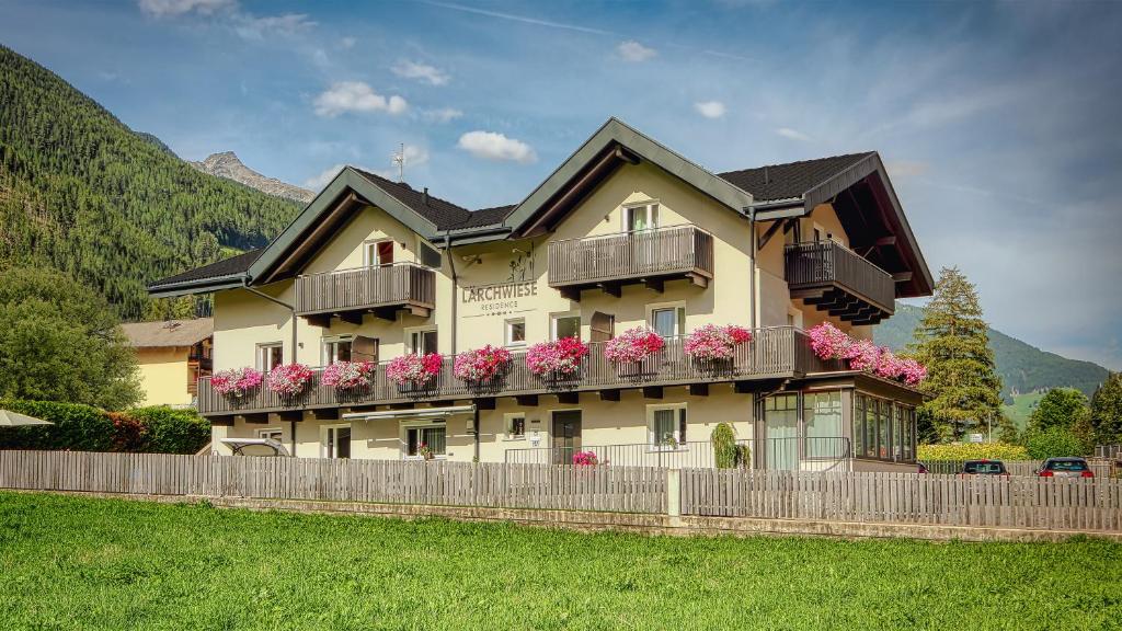 a building with flowers on the balconies of it at Residence Lärchwiese in San Giacomo