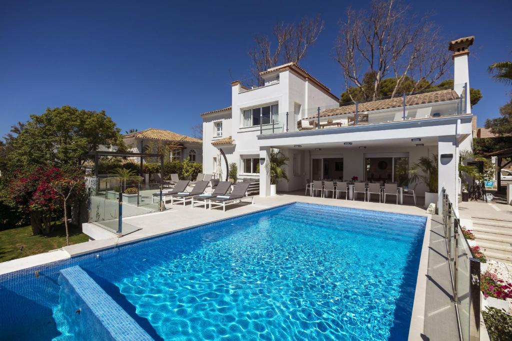 a villa with a swimming pool in front of a house at Villa La Perla by Finest Rentals in Marbella