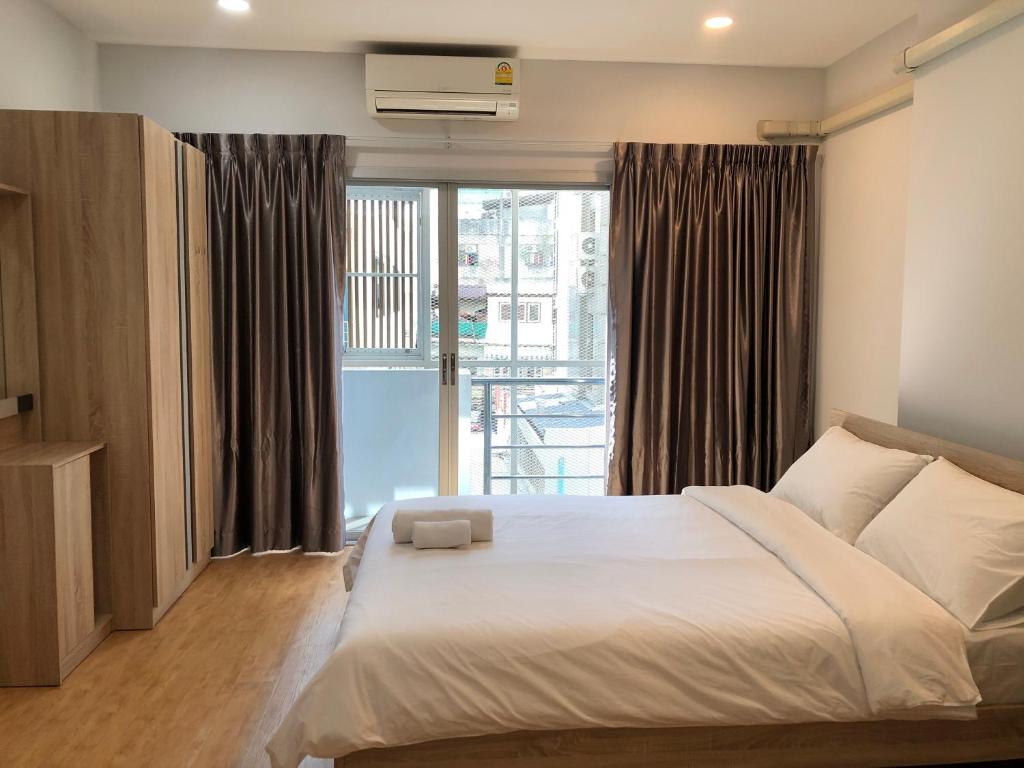 a bedroom with a bed and a large window at Tang Guang Aeum Coffee Residence in Bangkok