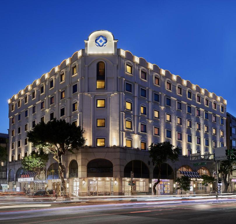 un gran edificio con un reloj encima en The Riviera Hotel Taipei, en Taipéi