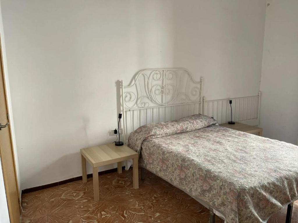 - une chambre dotée d'un lit et d'une table de chevet dans l'établissement Fonda Joan, à Santa Coloma de Farners