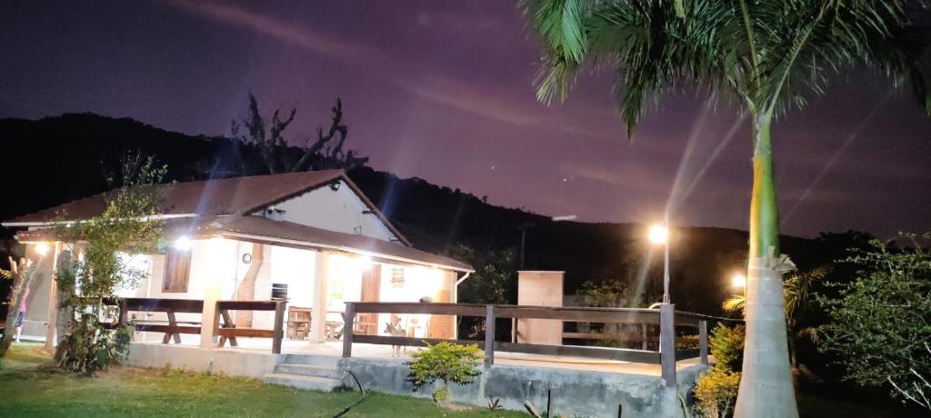 ein Haus in der Nacht mit einer Palme in der Unterkunft Sítio Vista da Serra in Lavrinhas