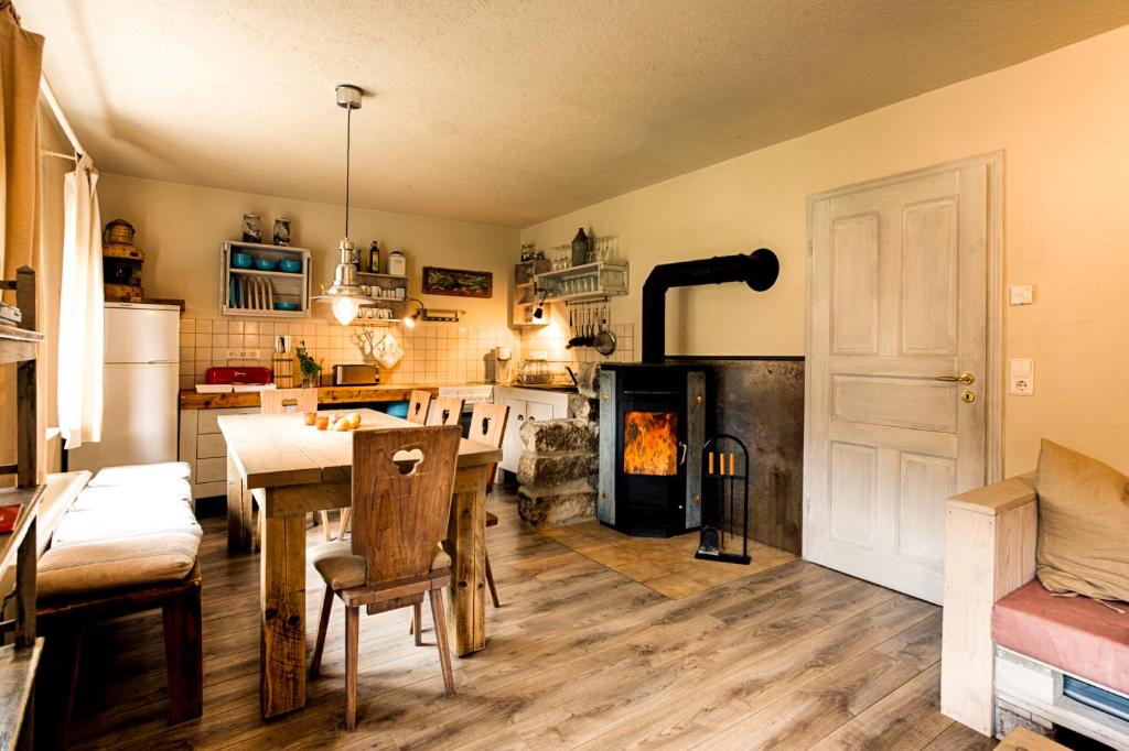 eine Küche mit einem Esstisch und einem Kamin in der Unterkunft Ferienhaus Strandhaus in Bad Schandau